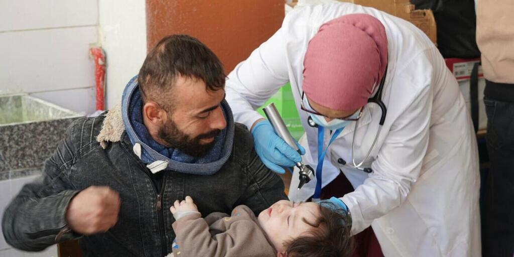 Un médico examina a un niño en una escuela en el Líbano como parte de un esfuerzo de una organización no gubernamental local, Mousawat, para brindar atención médica primaria a las personas desplazadas por el conflicto actual.